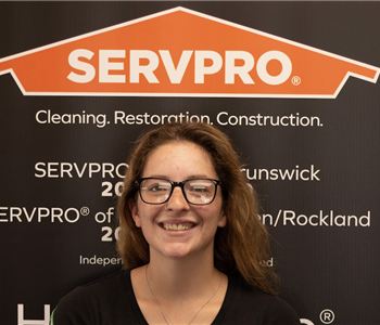 SERVPRO employee in front of logo