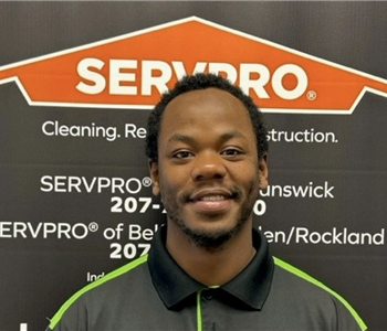 SERVPRO employee in front of logo