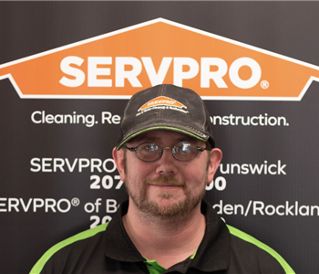 SERVPRO employee in front of logo