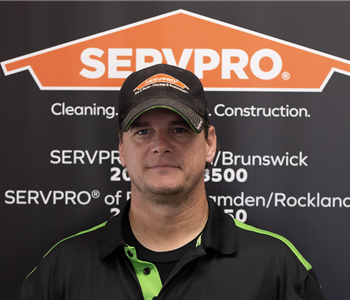 SERVPRO employee in front of logo