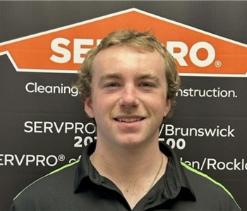 SERVPRO employee in front of logo