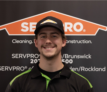 SERVPRO employee in front of logo