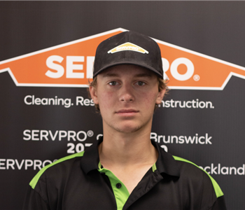 SERVPRO employee in front of logo