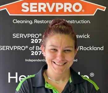 SERVPRO employee in front of logo