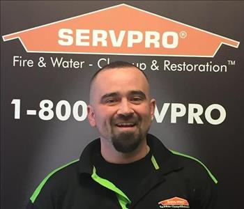 SERVPRO employee in front of logo