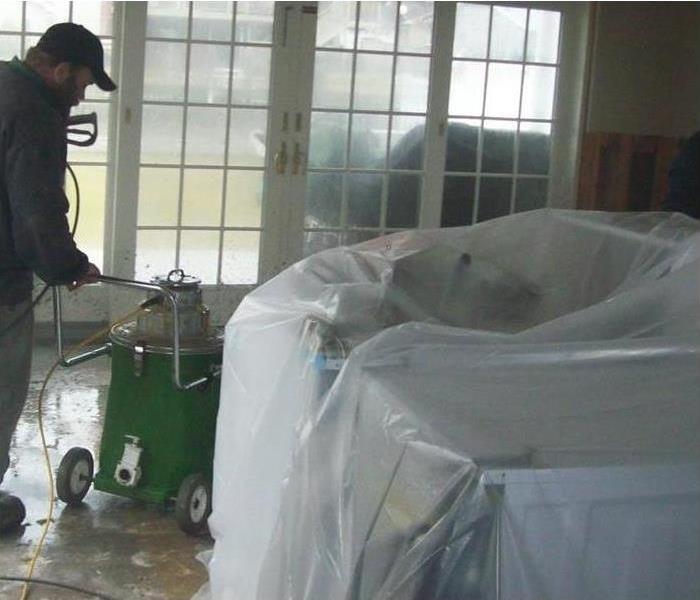 SERVPRO crew members remove water-damaged materials from a residence.